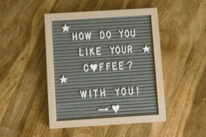 A cute, romantic coffee-themed message displayed on a felt letter board with decorative stars and hearts.